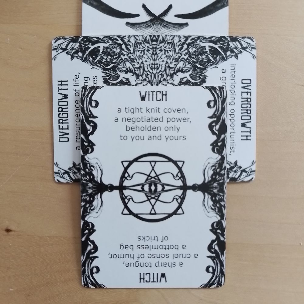 A Spindlewheel card, Witch (a tight knit coven, a negotiated power, beholden only to you and yours; or reversed, a sharp tongue, a cruel sense of humour, a bottomless bag of tricks) played on top of Overgrowth