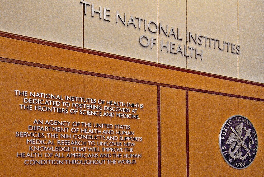 Wall display at the National Institutes of Health featuring a mission statement about advancing medical research, alongside the U.S. Public Health Service emblem.