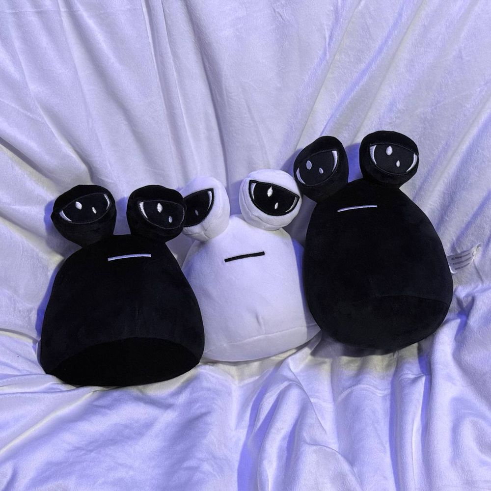 The same three pou plushies on a light background facing the camera.
The pou colors are in order: black, white, black.
