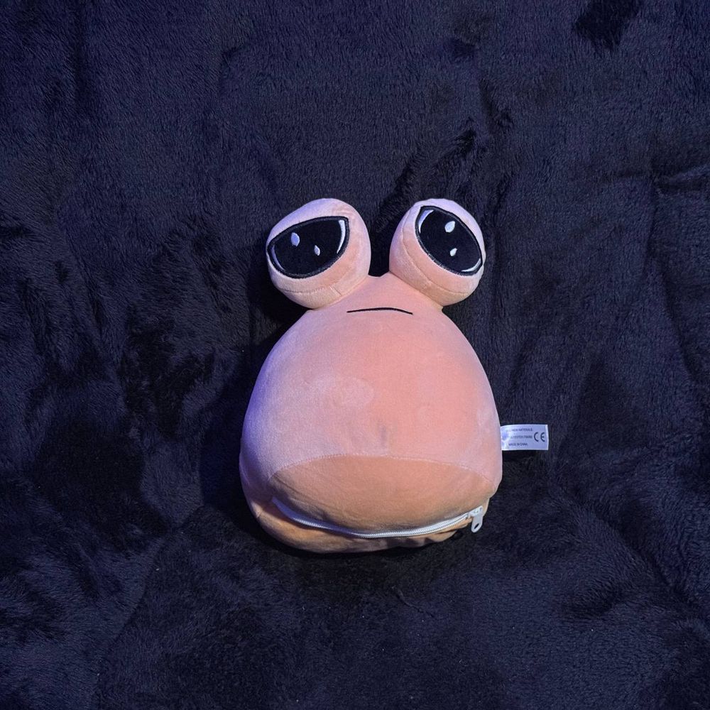 A pou with a zipper on the bottom, on a dark background facing the camera.