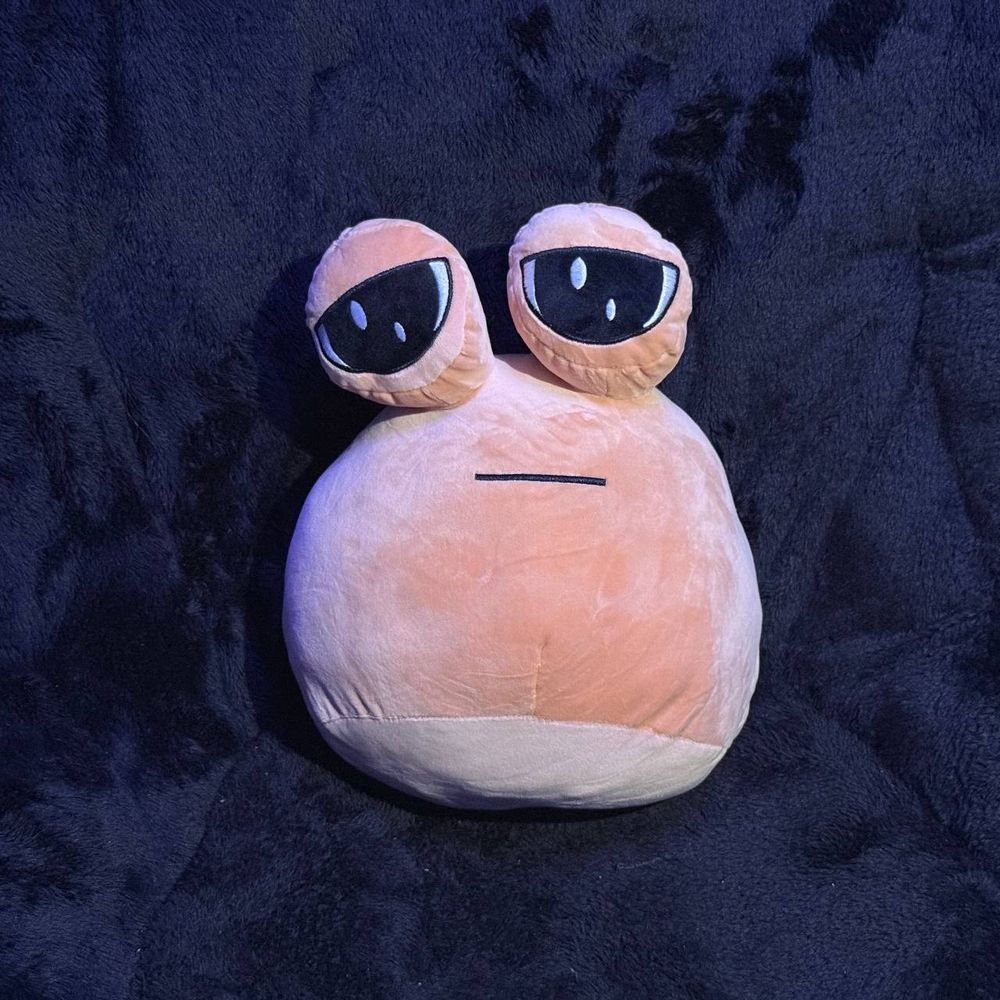A standard design pou that's noticeably bigger than the standard size, with a dark background behind.