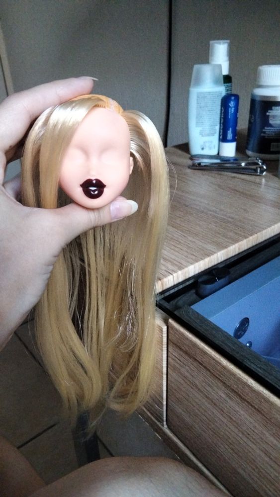 Cabeza de muñeca Bratz de tez clara, solo tiene un anillo de injerto de pelo, el resto es calvo. Tiene el rostro despintado salvo los labios.