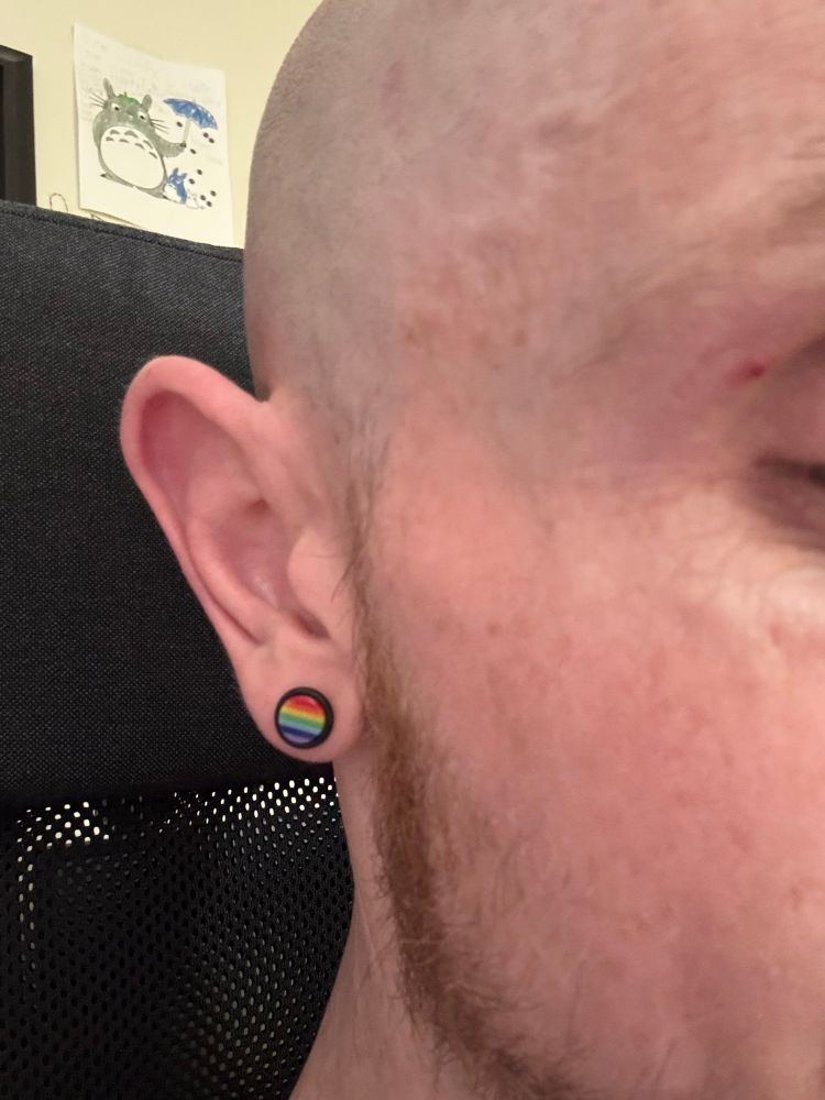My huge ear, with a large stud earring. It is the rainbow colours in a pride flag style. 
