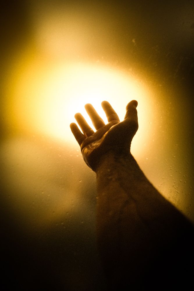 A hand reaching towards ambient light 