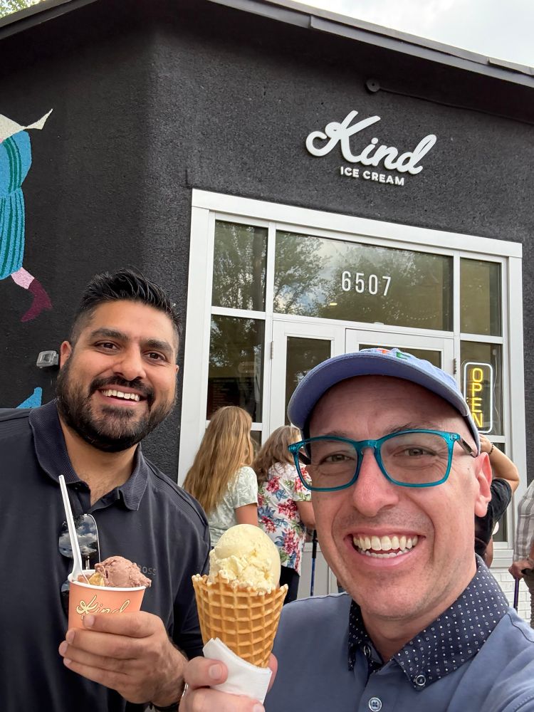 Andrew and Arif holding ice cream while standing in front of Kind Ice Cream.