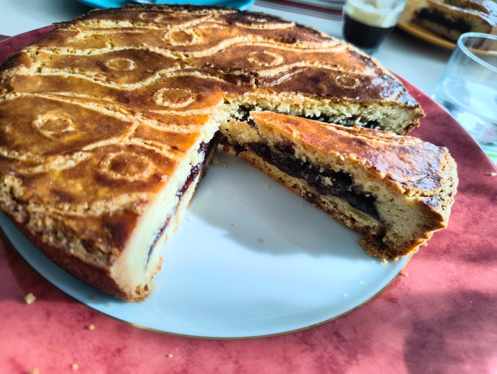 Le gâteau coupé avec une part détachée, on voit qu'il est à la confiture de cerise