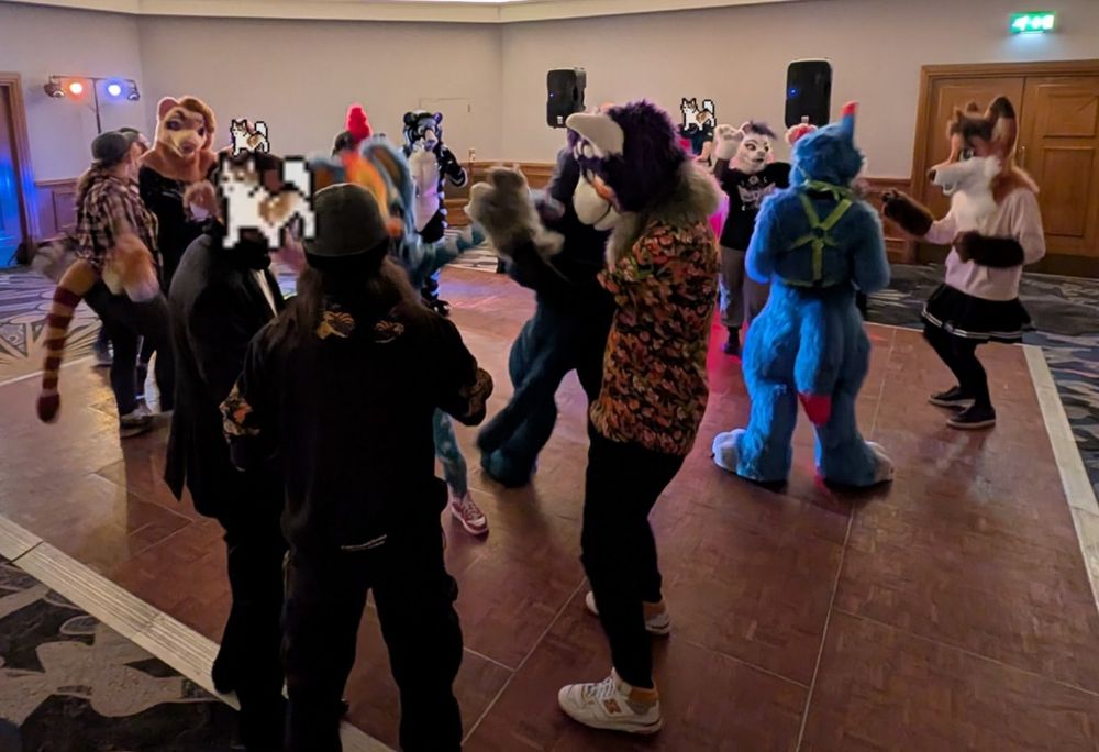A bunch of furries wearing fursuits dancing on the dance floor