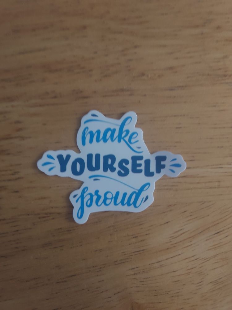 A cut out sticker saying "make yourself proud" in blue live laugh love font