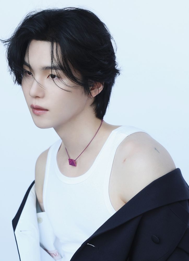 Yoongi in a white tank top. His scar and tattoo are visible