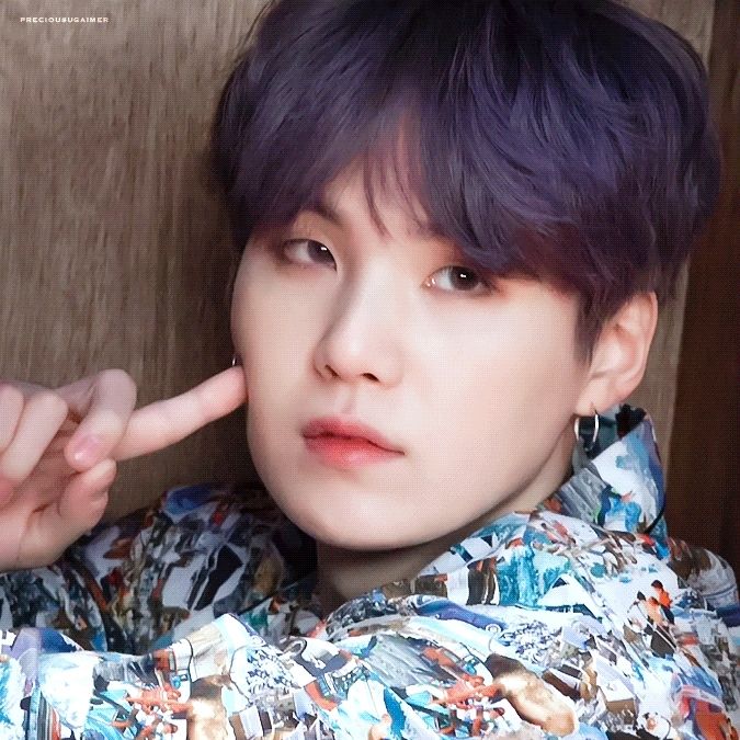 Yoongi holding his finger against his cheek