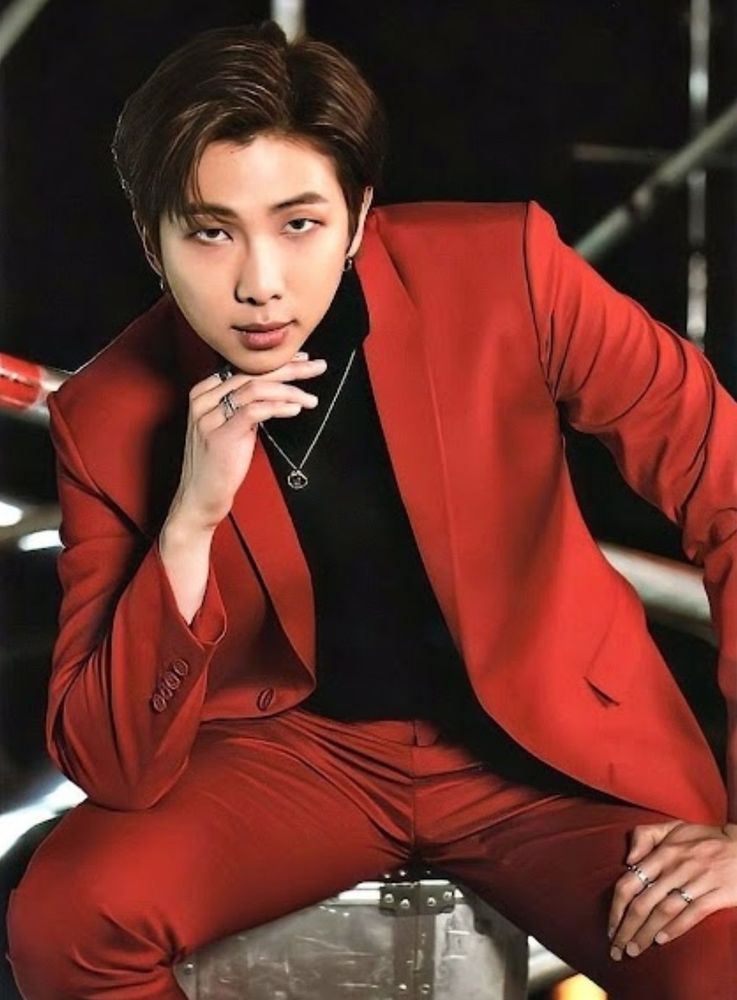 Kim Namjoon wearing a red suit with a black shirt.