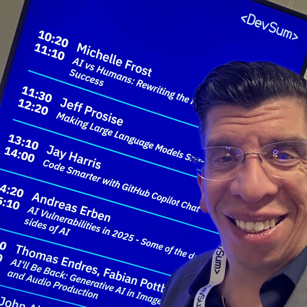 Jay Harris standing in front of a monitor showing the day’s session schedule at DevSum.