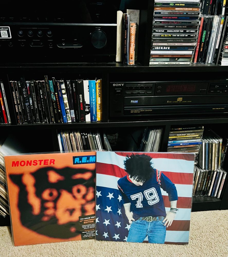 Ryan Adams (Gold) album and R.E.M. (Monster) album near a mixed media stereo bookshelf.