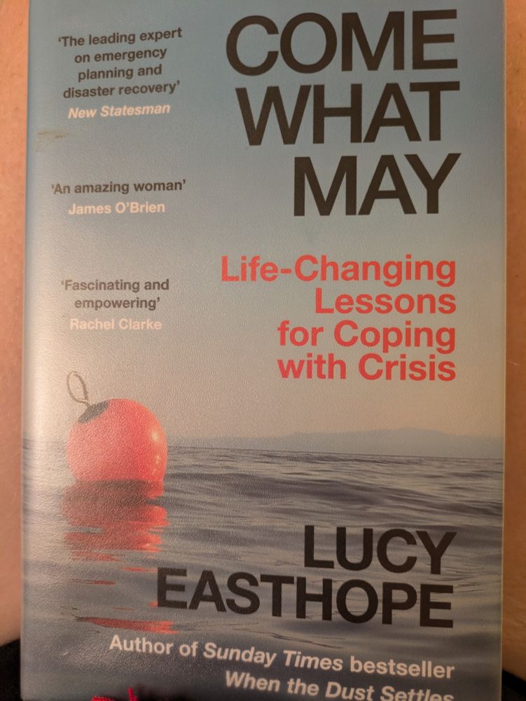 Come What May by Lucy Easthope (Life-changing Lessons for Coping with Crisis. Hardback cover shows and orange buoy floating on the sea with a far horizon.