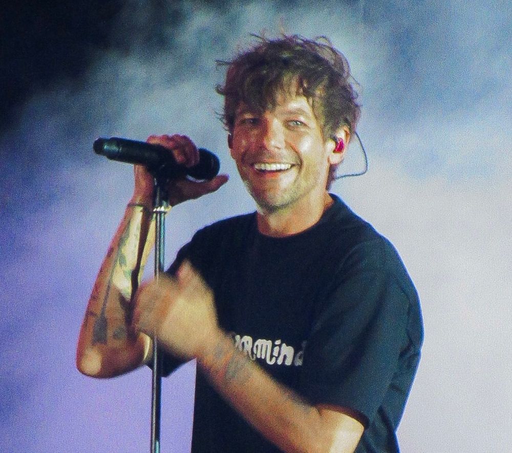 a close up of Louis smiling on stage