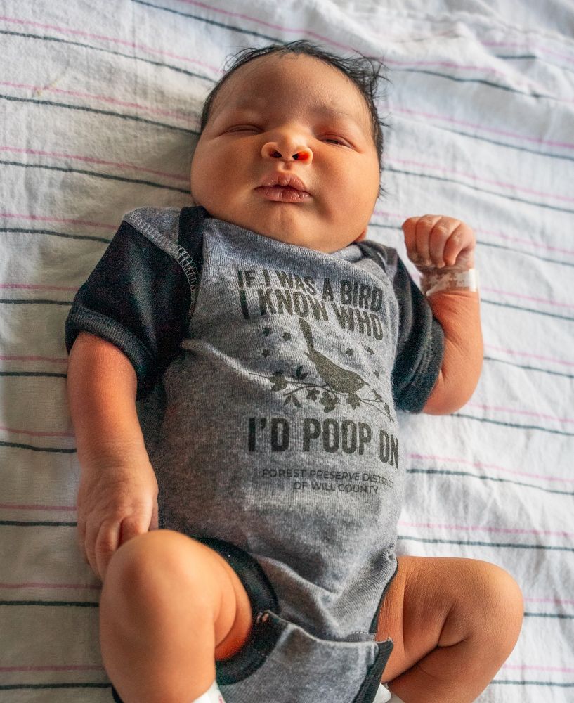 Baby wearing a onesie that says if I was a bird, I know who I'd poop on. 