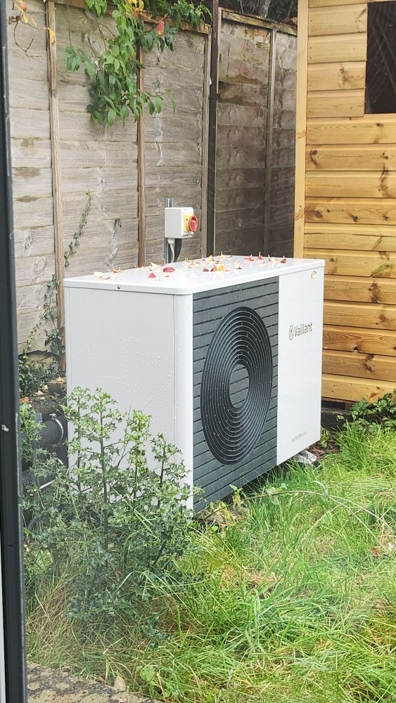 A photo of our heat pump in the back garden, taken through a window in the house.
