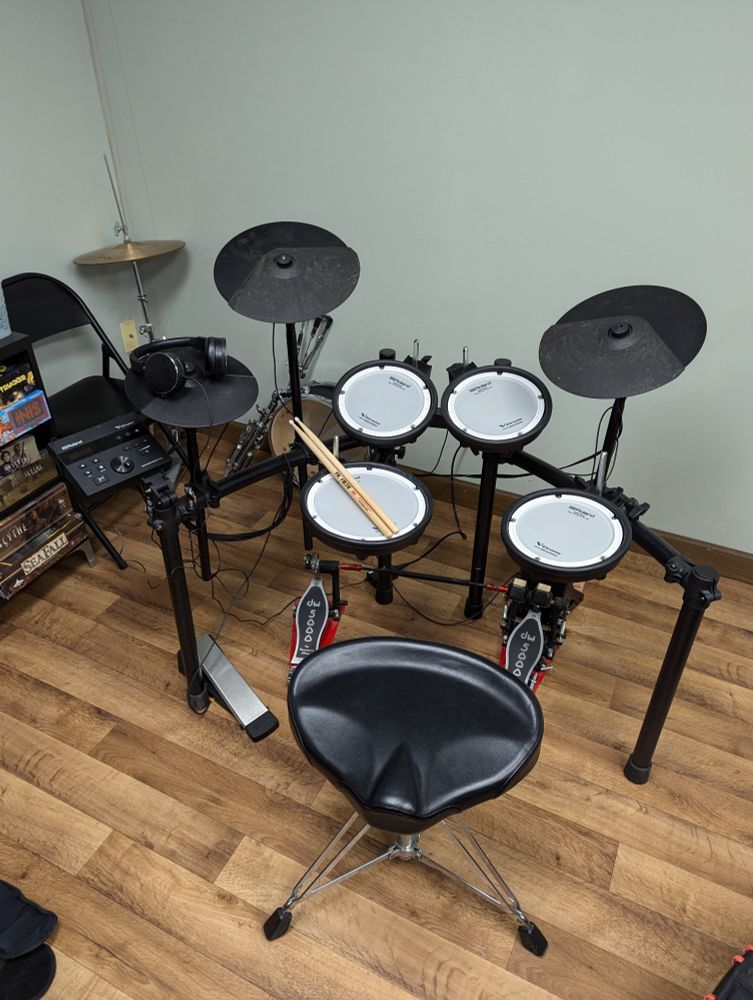 Roland TD-07KV drum set with board games and real hi-hat and snare in background.
