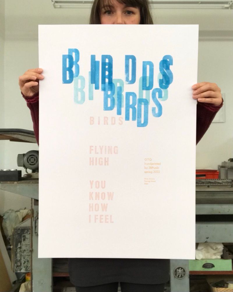 Eine Person hält ein großes Plakat auf dem mit lasierendem hellblau und rosa
Birds 
flying 
high
You
Know
How 
I Feel
Gedruckt steht.
