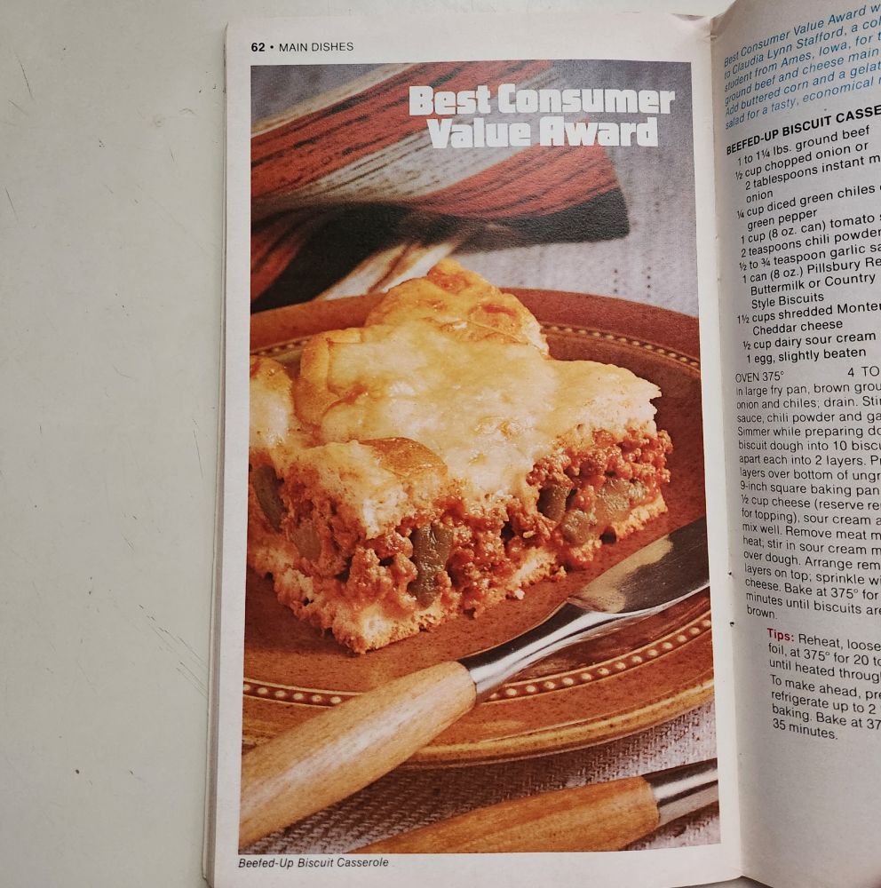 Photo of Beefed-Up Biscuit Casserole on a brown stoneware plate. It's a cut square that you can see a mix of meat and chopped vegetables inside, with a biscuit crust. At the top is a heading that says, "Best Consumer Value Award."