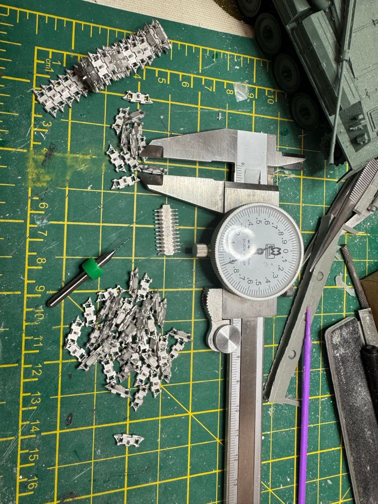 Assembling a 1/35 scale tank track from individual cast links, brass wire and a 0.5mm drill.