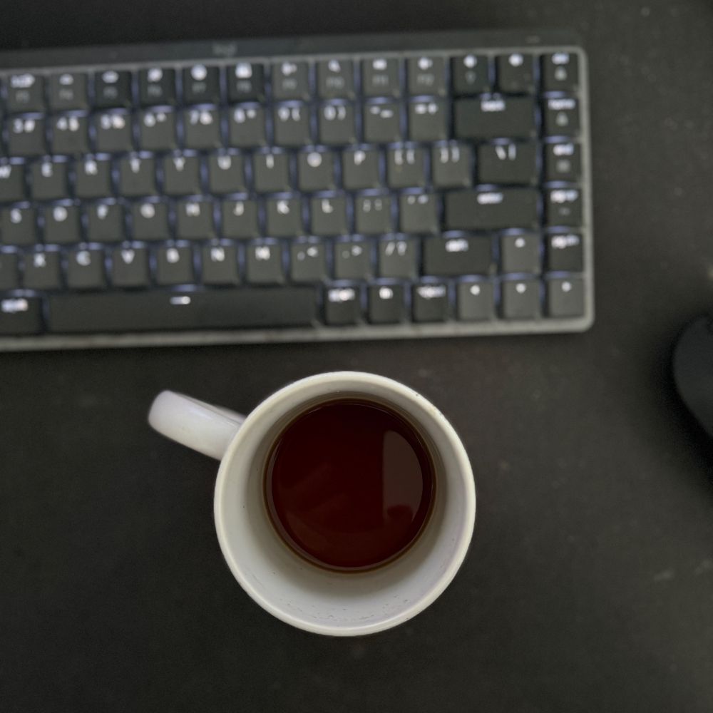 Black coffee in white mug with keyboard and mouse at my desk