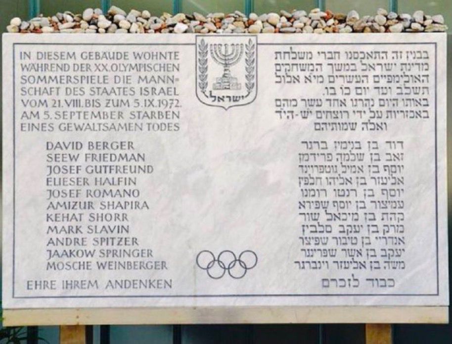 Gedenktafel für die israelischen Opfer mit Namen. Mittig oben eine Menora, unten die Olympischen Ringe.