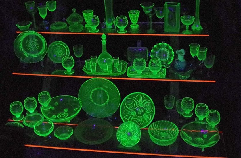 Many uranium glassware glowing on a shelf 
