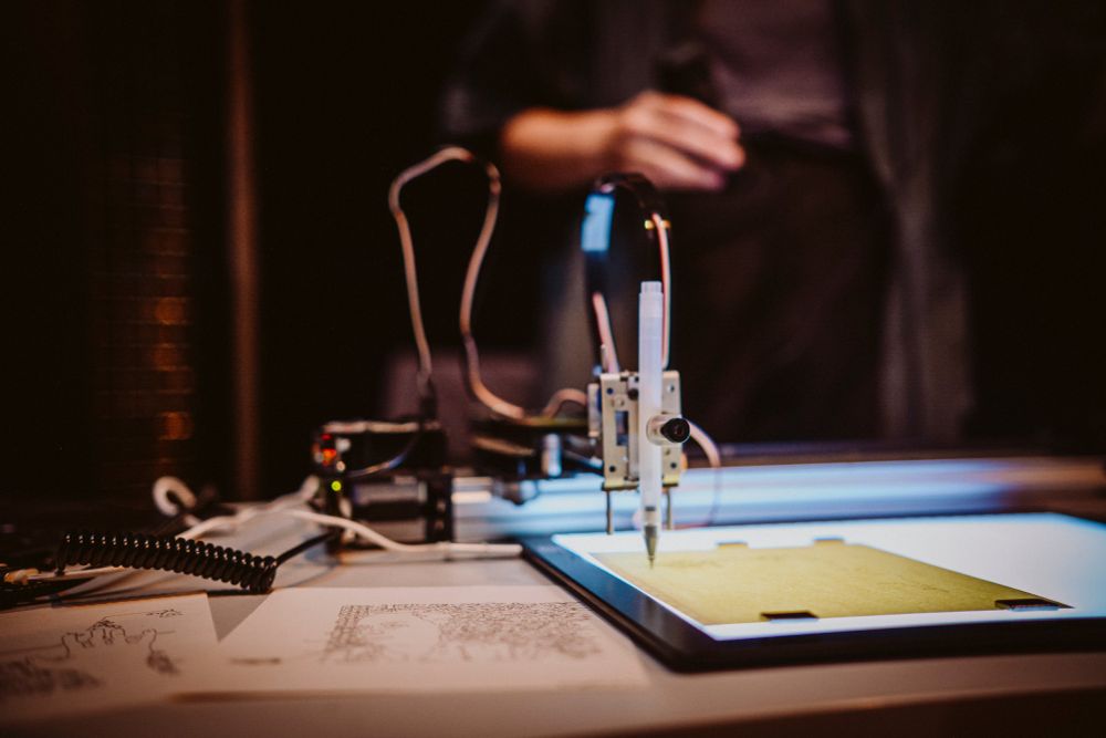 a pen plotter at work in a dark room