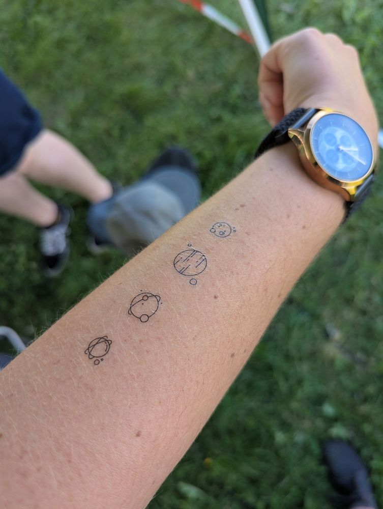 Bleeptrack's left arb with four temporary tattoos of line art planets 