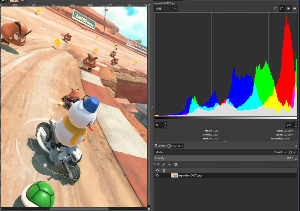 a screenshot of Mario Kart World on its first track. it's opened in GIMP, showing a histogram of RGB values