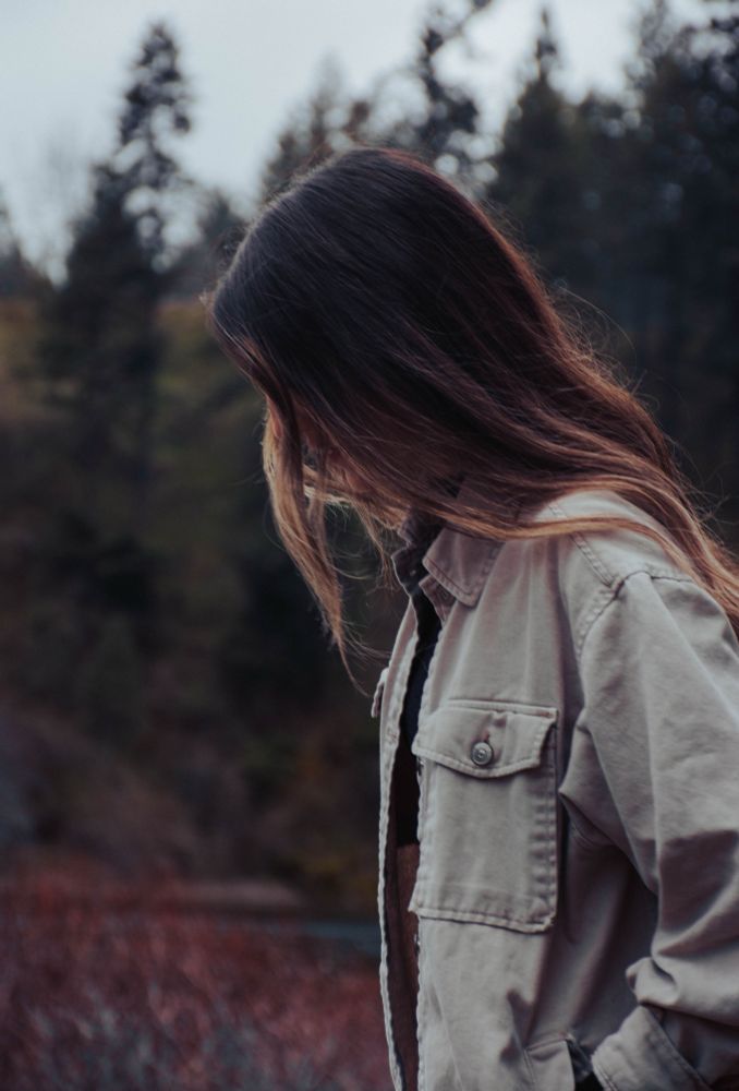 Portrait photo of a woman in profile. Lake and mountain in background.