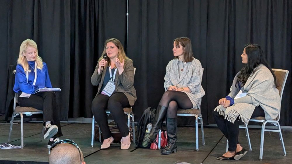Four women astronomers, Kimberly Arcand, Nicole Drakos, Maddie Lucey, and Amruta Jaodand sit on stage.