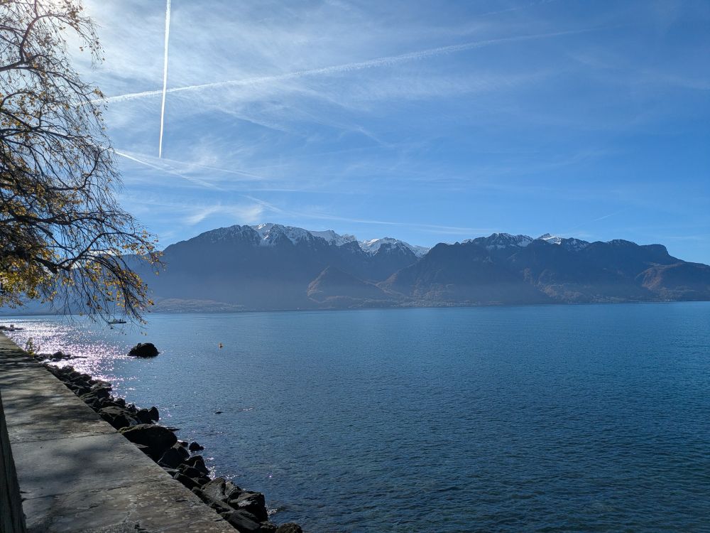 View of the Grammont mountain in France from the Swiss shore of Lake Geneva on a sunny day. The mountain has snow on the top. 