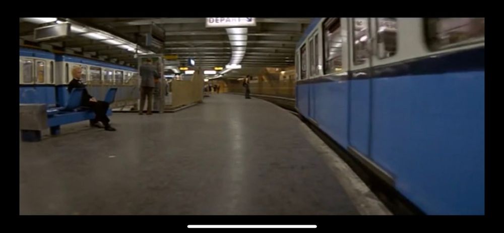 Plan sur le metro en station. Christophe Lambert en smoking assis sur un banc
