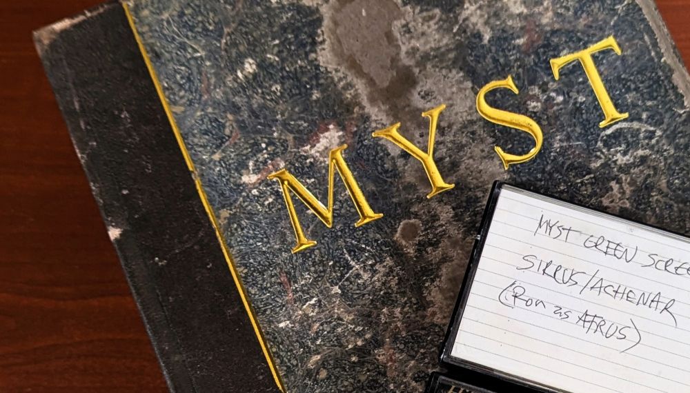 A replica of the book from Myst. On top of the book, there's a videocassette labeled "Myst green screen, Sirrus/Achenar (Ron as Atrus)."