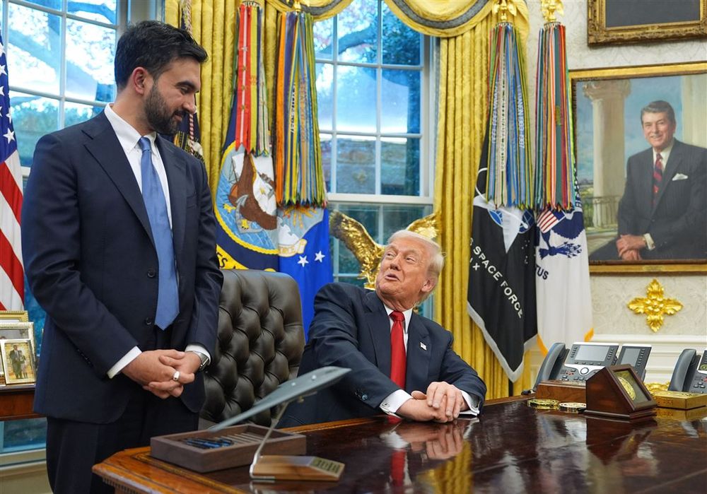 Trump grinning up at Mamdani from his desk in the Oval Office. 
