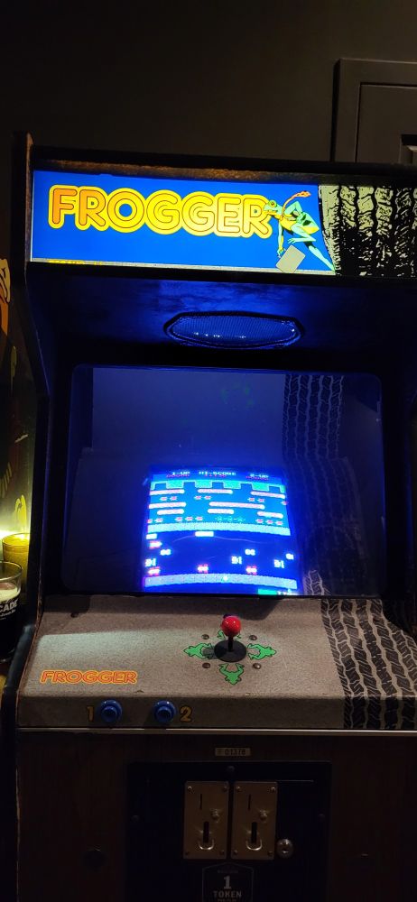 An arcade cabinet with the Frogger game on it