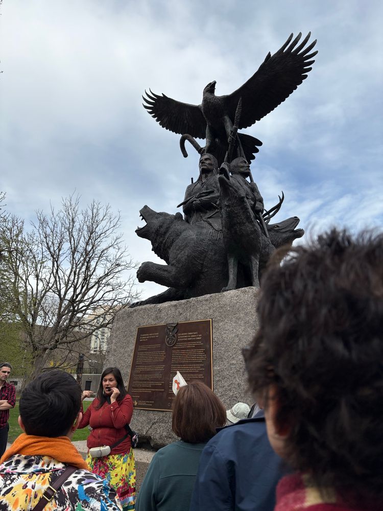 Tour guide talking in front of sculpture with eagle.