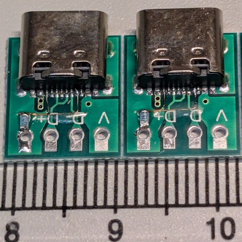 USB Type-C（USB 2.0用）のレセプタクルの裏側です緑色の基板に取り抜けられています
手前側に置いてあるのは大きさを知るための物差しです
電源をとるためCC1とCC2をまとめて抵抗でプルダウンしてますが5.1kΩが手元になかったので4.7kΩでごまかしてます😝