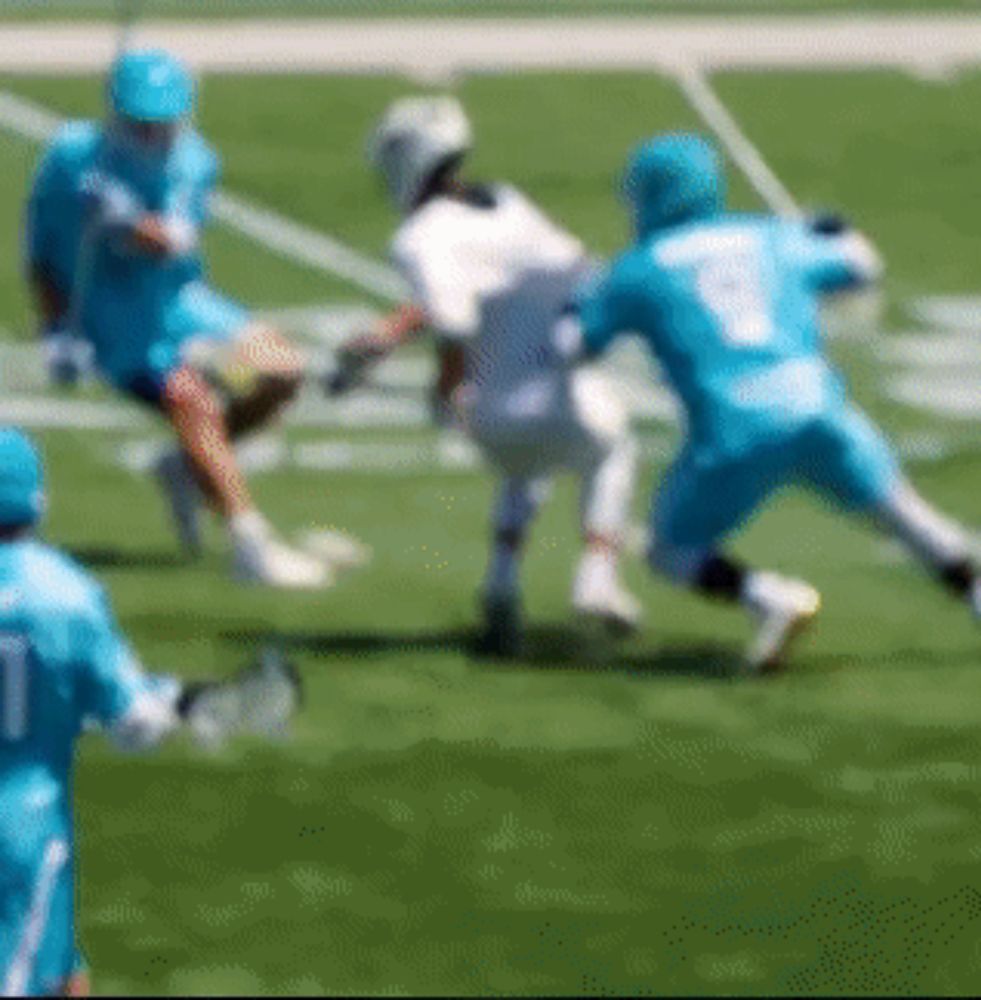 a blurry picture of a lacrosse game with a player wearing the number 7 on his jersey