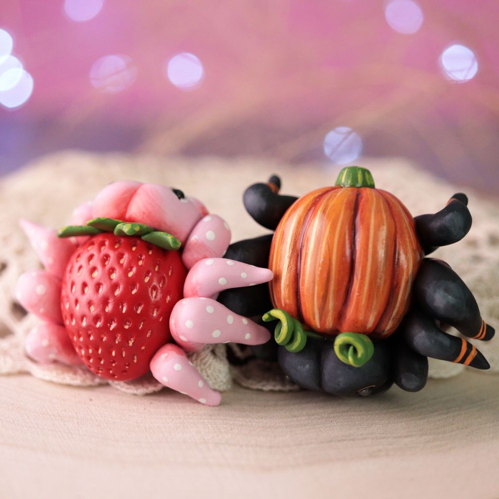 A strawberry spider and a pumpkin spider (figurines) 
