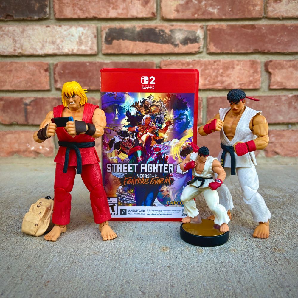Jada Toys Street Fighter II Ken Masters and Ryu figures posed with Street Fighter 6 and a Ryu amiibo for Nintendo Switch 2.