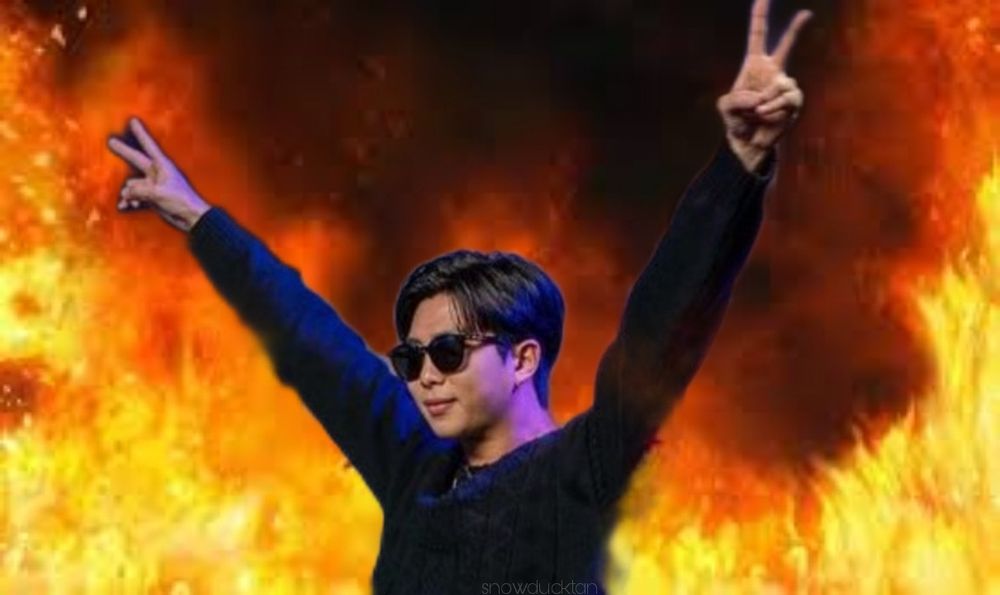 Meme of Namjoon raising his arms with peace signs and sunglasses. The background is just fire.