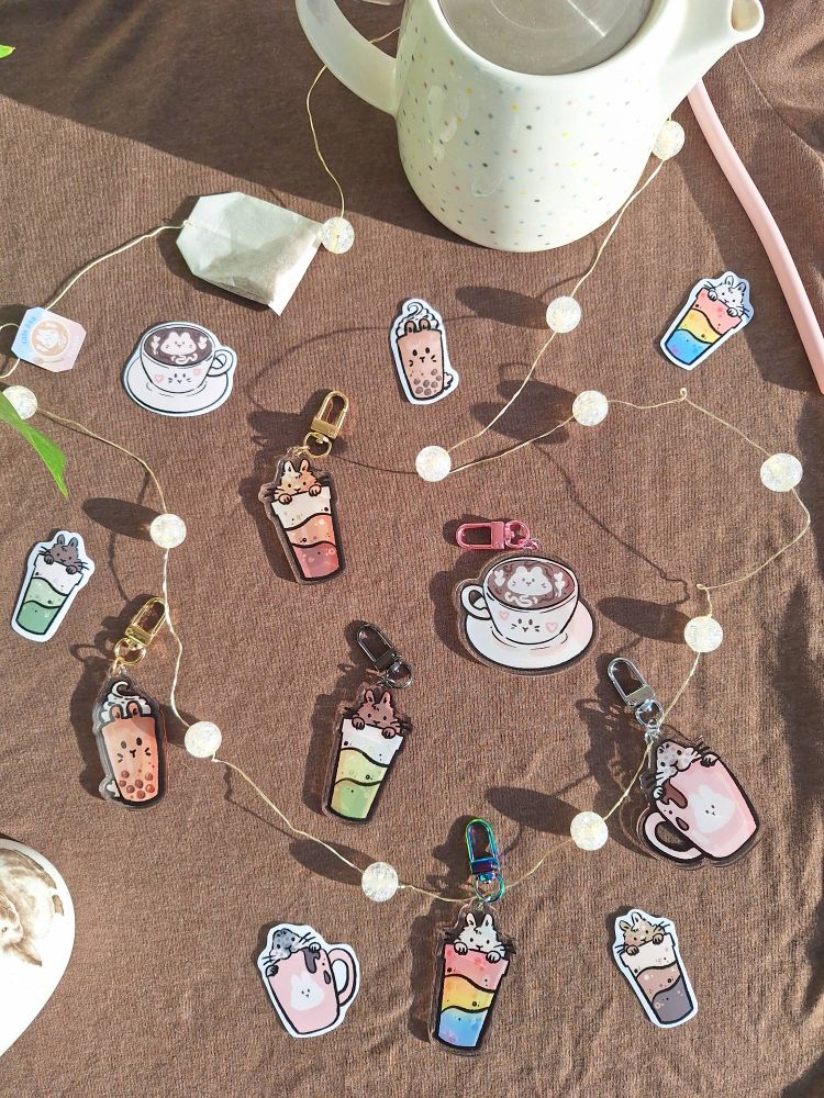 A photo of different keychains and stickers, all featuring bunnies combined with drinks.