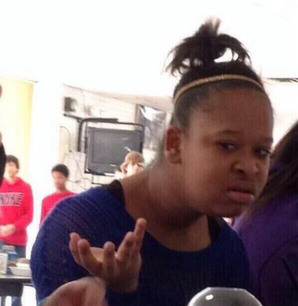 Classic “wtf” meme of girl in purple shirt with her hand up.