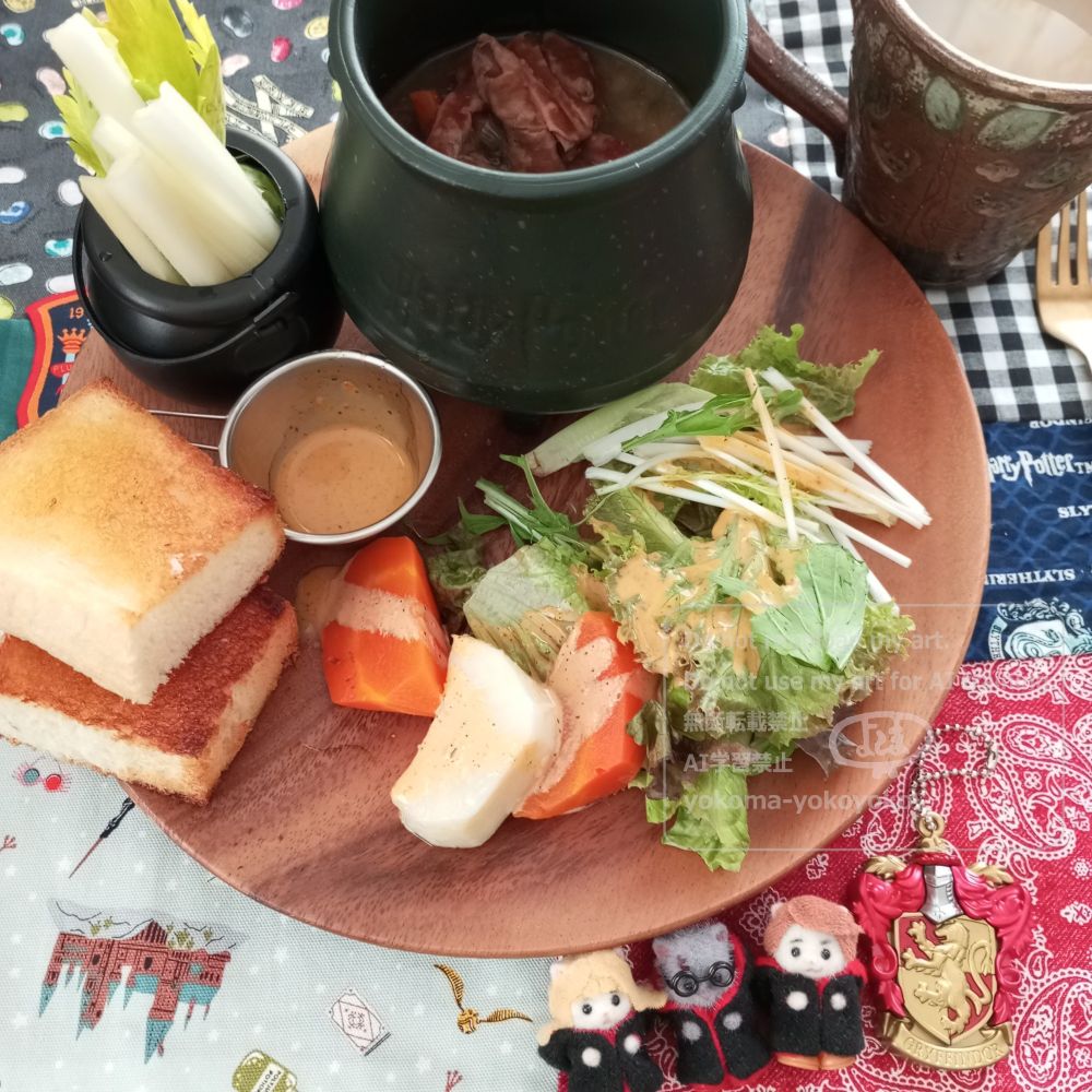 クロスはハリポタ柄。木のお皿にサラダ、パン、小さな魔女鍋に入ったセロリのスティックサラダ、大きな魔女鍋にもつ煮が入っています。飲み物はチャイ。シルバニアのペルシャ猫の赤ちゃん扮するハーマイオニー、ハリー、ロンが並んでいます。