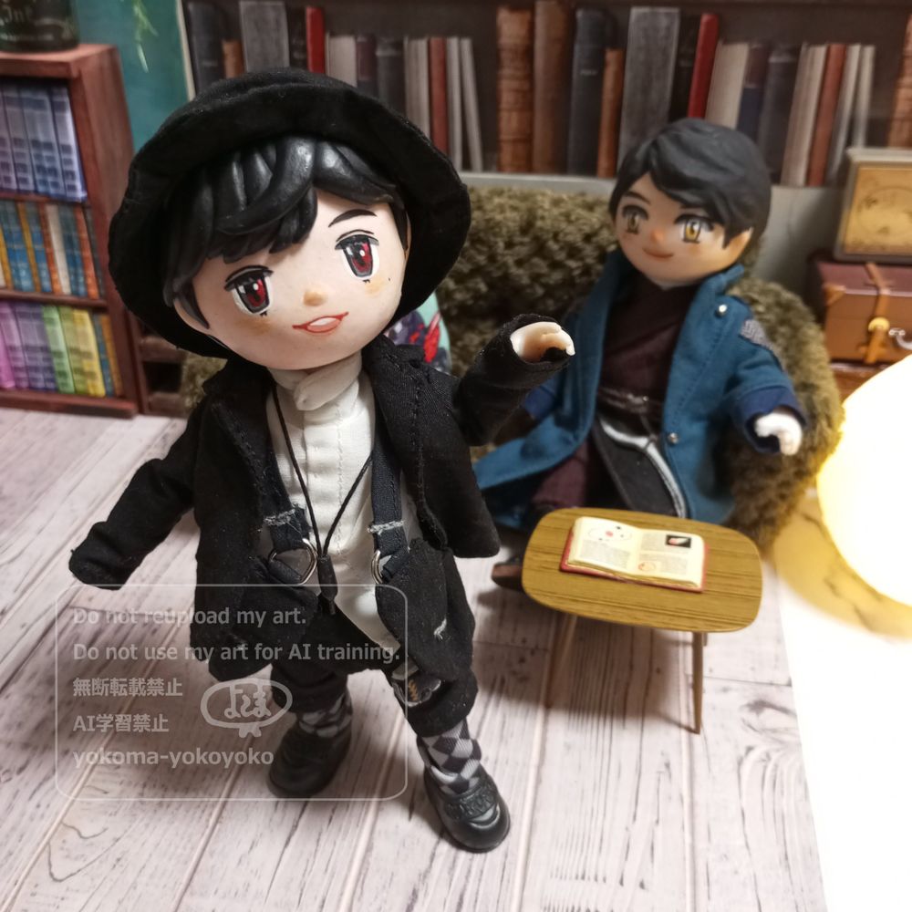 セリアドールボディに粘土で作ったお顔の飛羽真先生が左手を上げて左足を出して見てみてしています。
靴下は灰色に黒のアーガイル柄。
後ろでソファに座っている賢人くん(同じくセリアドール)は、ほーんって顔してニコニコしています。