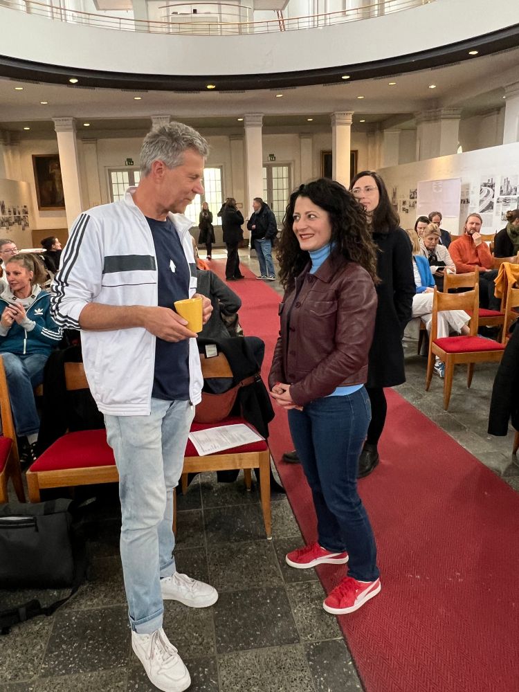 Cansel Kiziltepe spricht mit einem der Teilnehmer der Veranstaltung im Saal.