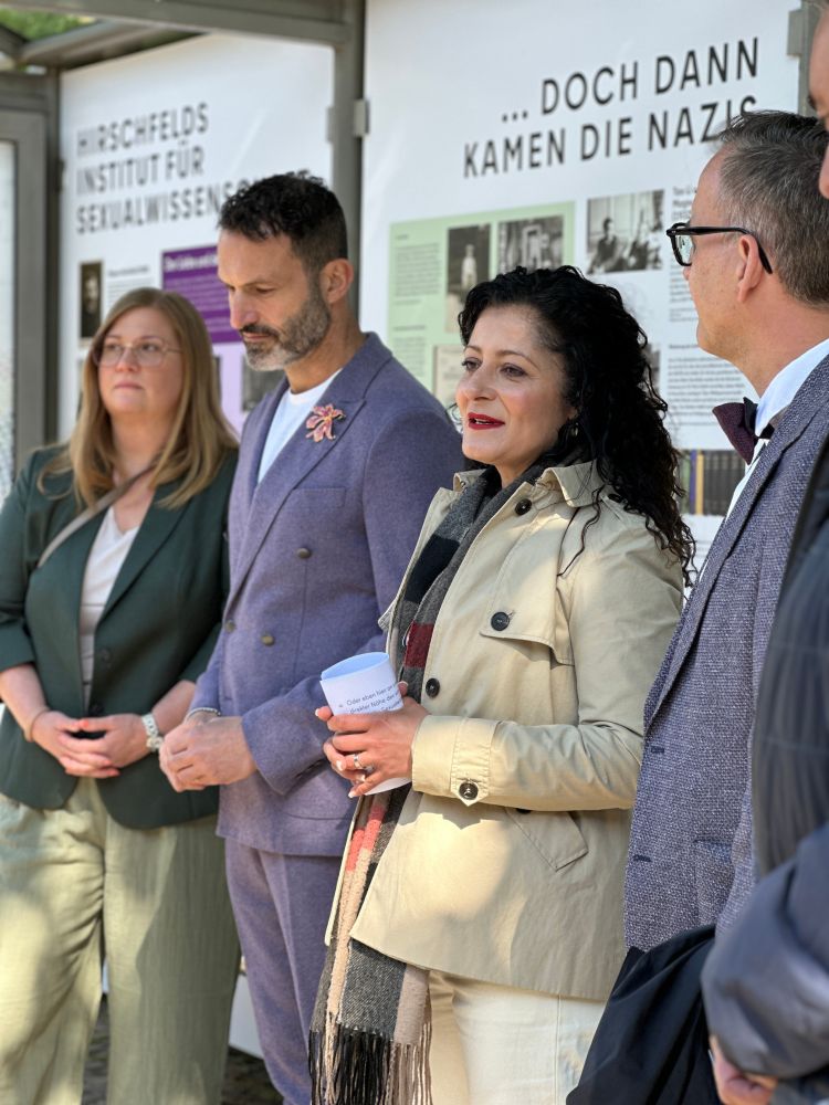 Senatorin für Arbeit, Soziales, Gleichstellung, Integration, Vielfalt und Antidiskriminierung Cansel Kiziltepe und die Ansprechperson der Landesregierung Berlin für die Akzeptanz sexueller und geschlechtlicher Vielfalt Alfonso Pantisano stehe vor der Gedenkhaltestelle "Magnus Hirschfeld" (BVG Bushaltestelle "Haus der Kulturen der Welt")